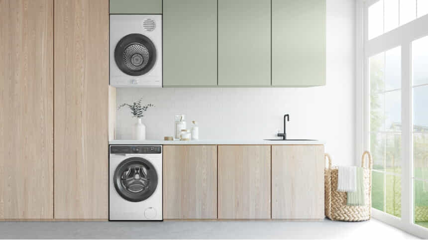 A Westinghouse mounted dryer and front load washer in a light timber and sage green laundry.