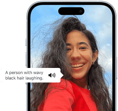 iPhone 15 displaying a VoiceOver announcement describing a photograph as: a person with wavy black hair laughing