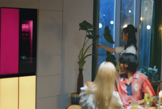 Woman entertaining her friends seamlessly at home with an LG MoodUP fridge.