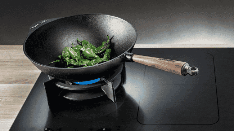 A wok cooking some vegetables.