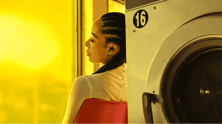 A woman wearing her Bose Ultra earbuds in a laundry mat