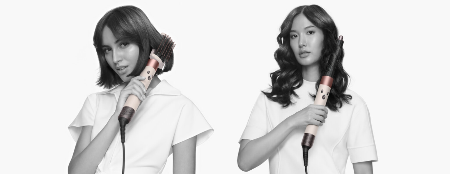 Two models hold a Dyson Hair Dryer and Dyson Airwrap in ceramic pink and rose gold