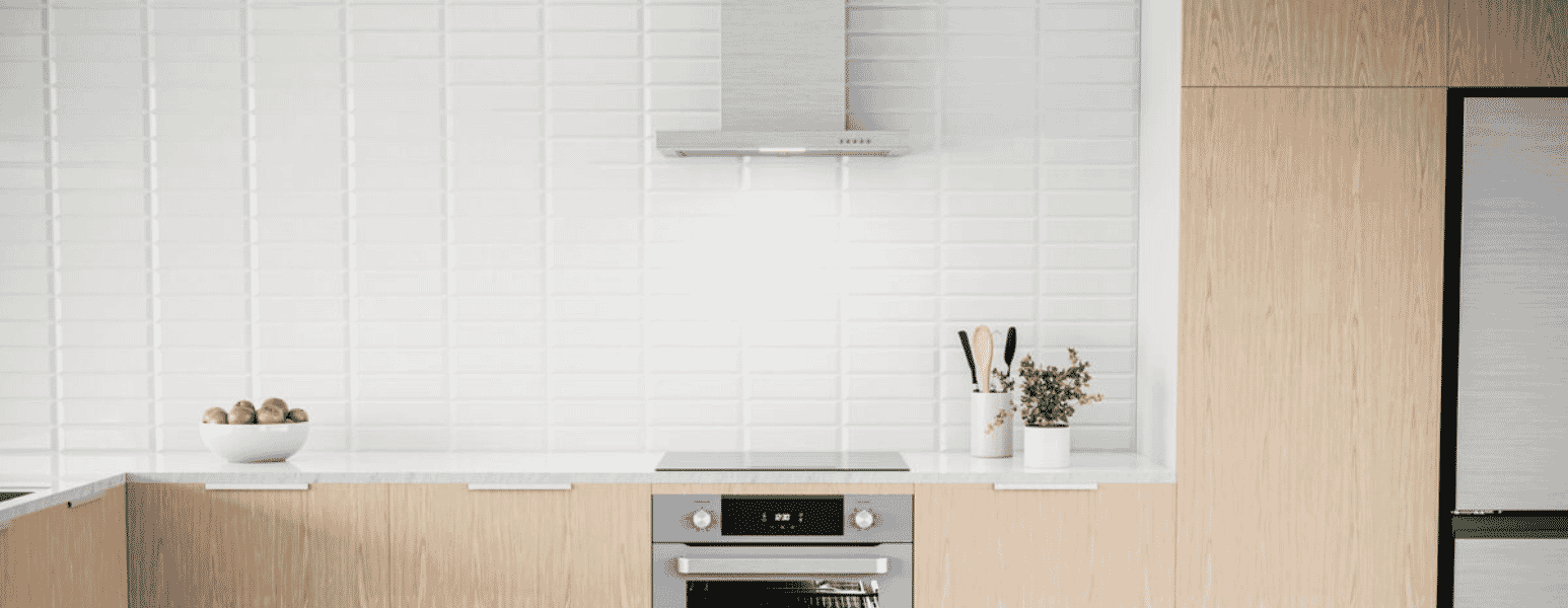 Black Hair rangehood and oven in a salmon kitchen