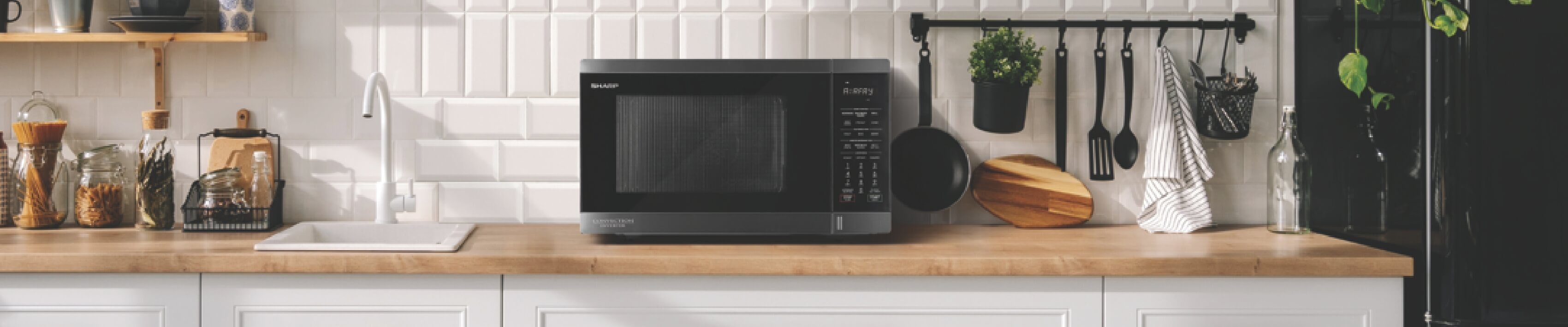 Black microwave on a wooden benchtop