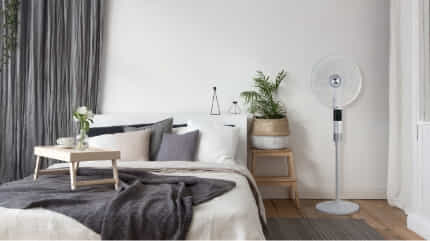 The De'Longhi 360 Degree Pedestal Cooling fan cools down a bedroom.