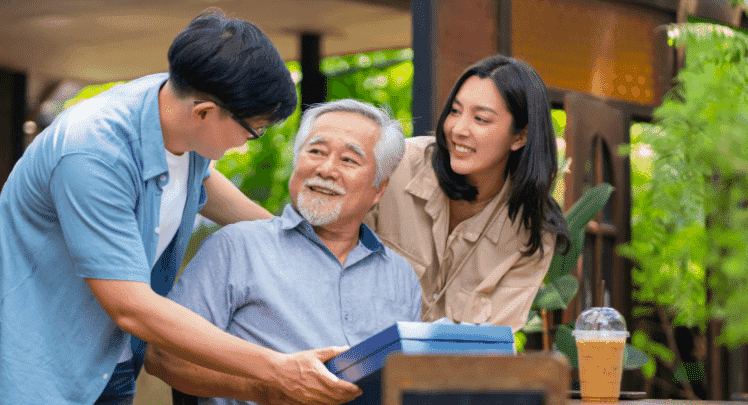 2 kids giving their Dad a Father's Day gift outside