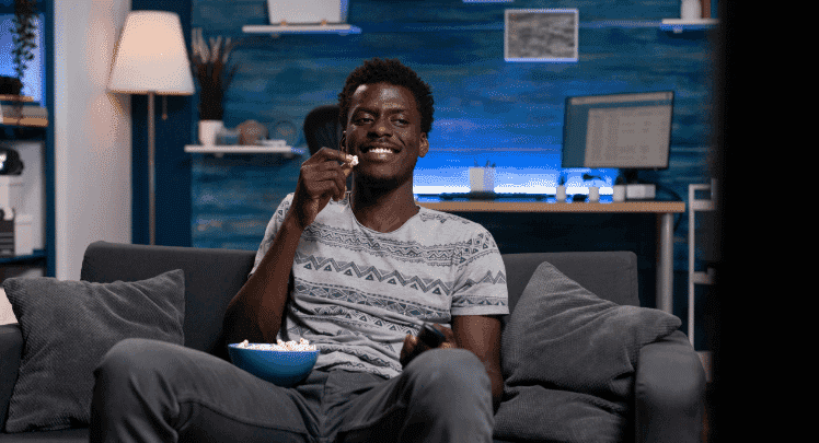 A guy sitting in his man cave watching TV