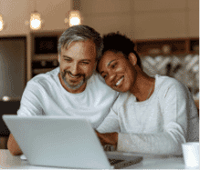 A man and woman sitting together looking at a computer