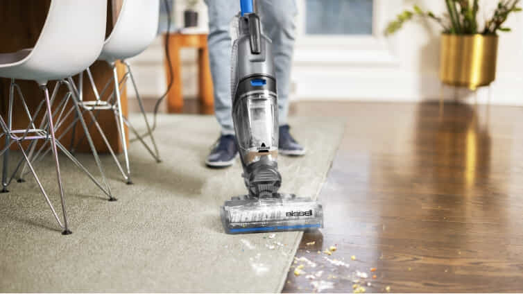 Man using Bissell CrossWave to clean carpet and hard floor.