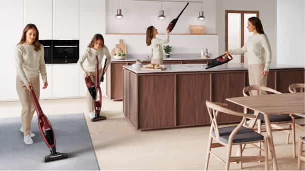 Woman cleans home with Electrolux stick vac.