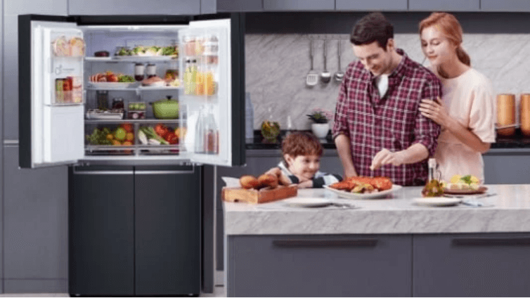 Lifestyle image of an LG Slim French Door Fridge with a family cooking in a modern kitchen