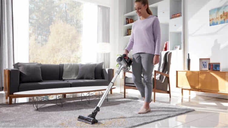 Woman vacuuming her floors with the LG CordZero 9K-Evolve.