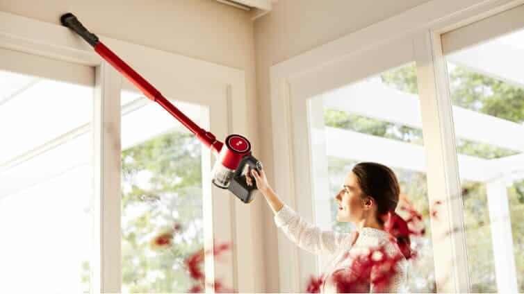 Woman vacuuming her windowsills with the CordZro A9N-Multi by LG.