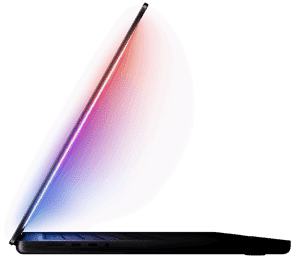 A slightly open MacBook Pro casts a multicoloured glow from the screen onto the keyboard