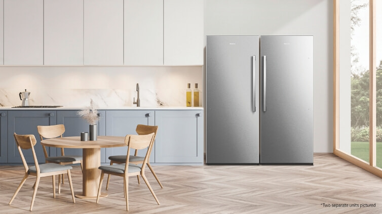 Two tall stand along silver Hisense freezers in big kitchen.