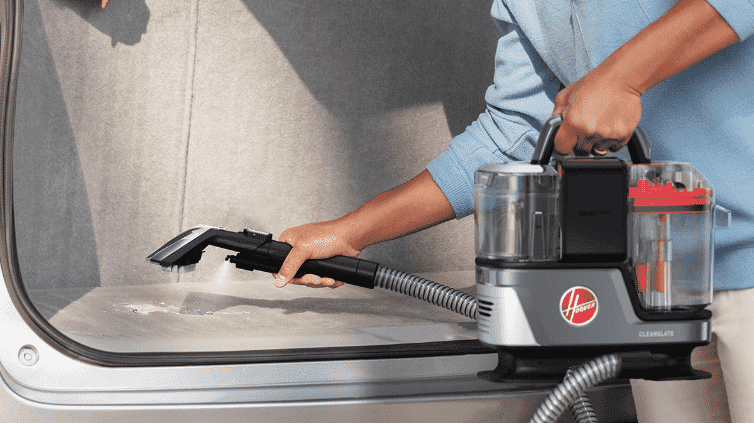 Hoover CleanSlate Spot Washer cleaning a the carpet inside a car