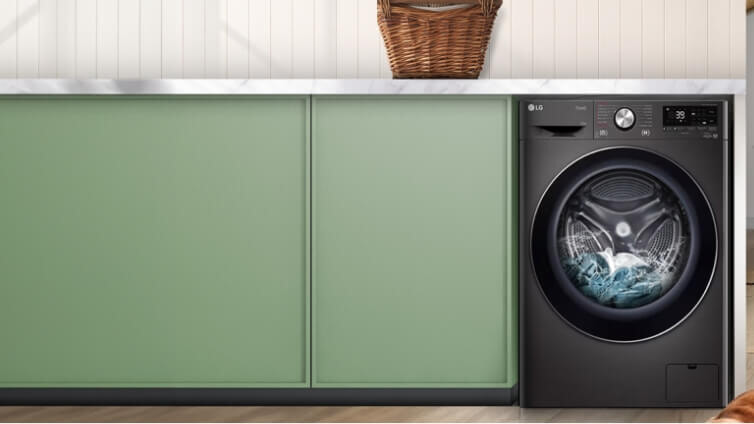 Front on shot of black LG washer in green laundry.