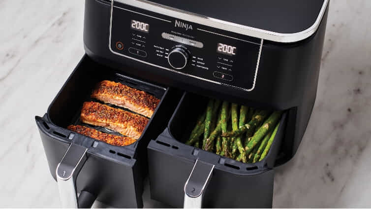 Dual drawer Ninja air fryer cooking salmon and veggies at the same time.