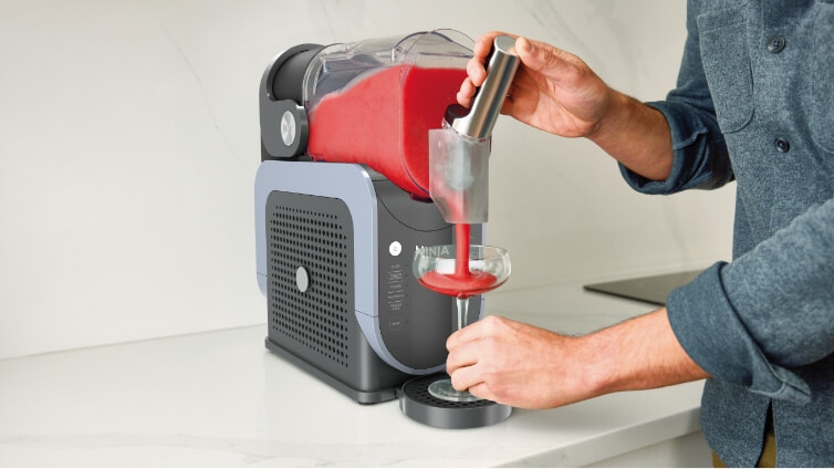 Man pouring himself a slushie from his Ninja machine