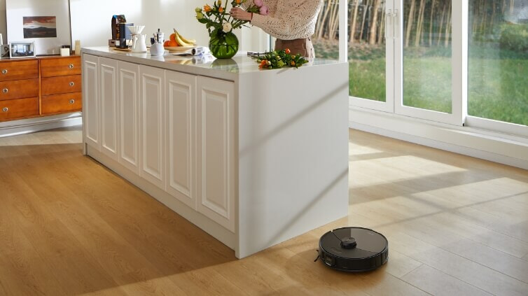 Roborock getting a close clean near a cabinet.