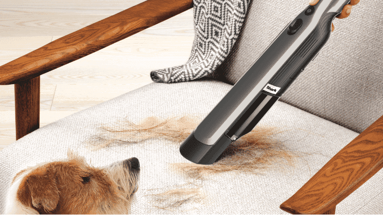 Close up image of the Shark ION Cordfree Handheld Vacuum cleaning pet hair from a chair.