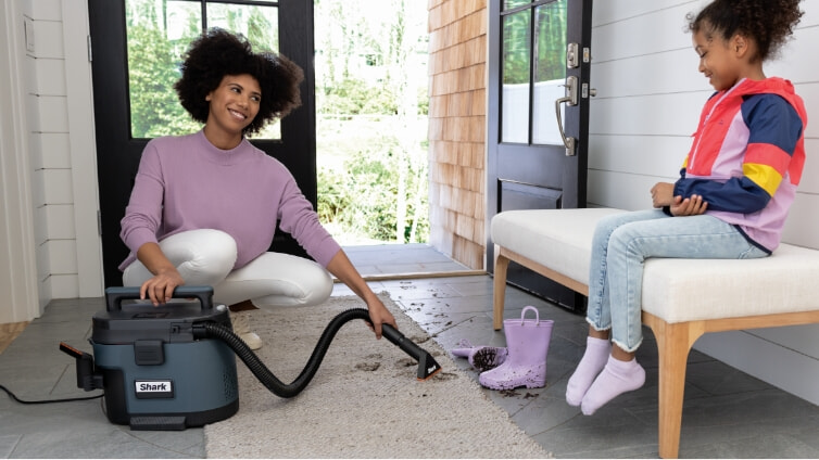 woman cleans dirt on carpet with Shark MessMaster Portable Wet/Dry Vacuum