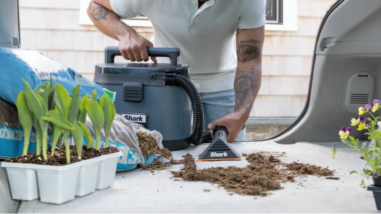 man cleans car with Shark MessMaster Portable Wet/Dry Vacuum