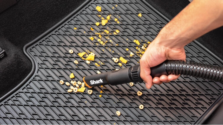 Close up image of the Shark ION Cordfree Handheld Vacuum cleaning pet hair from a chair.