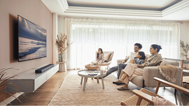 Lifestyle image of people watching TV with a Sony Soundbar in a living room.