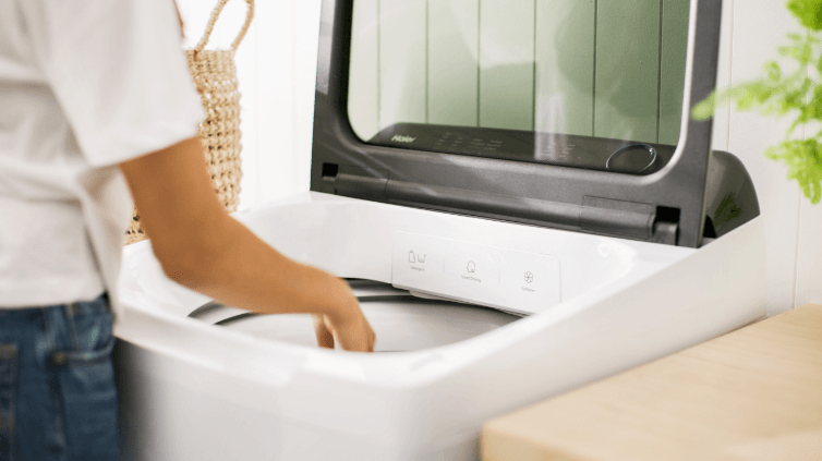 Woman loading her Haier Top Load Washer.