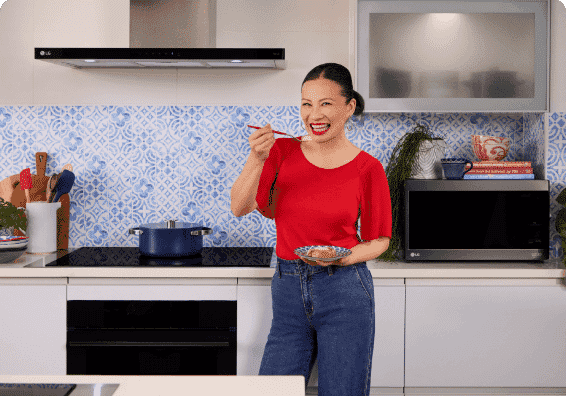 Image of Poh Ling Yeow smiling with a prepared meal in an LG kitchen.