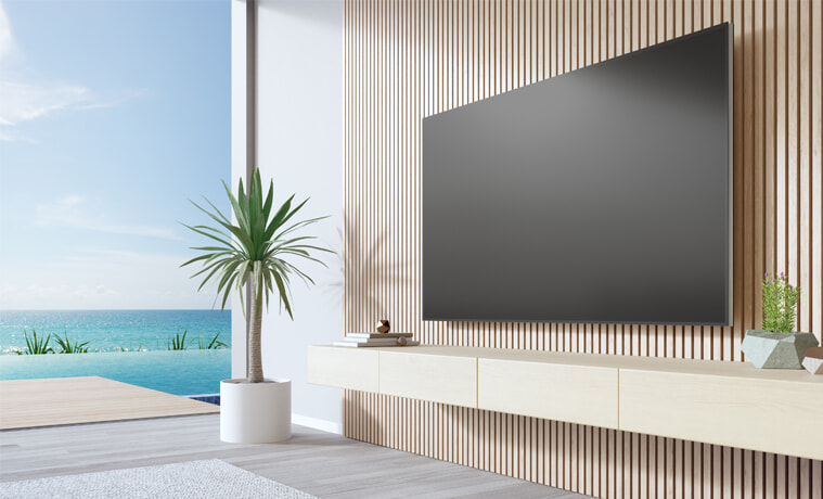 A large TV in a stylish modern living room by the beach.