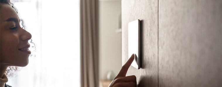 A woman activates her smart home security system.
