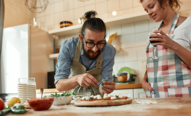 A young couple makes pizza together at home.