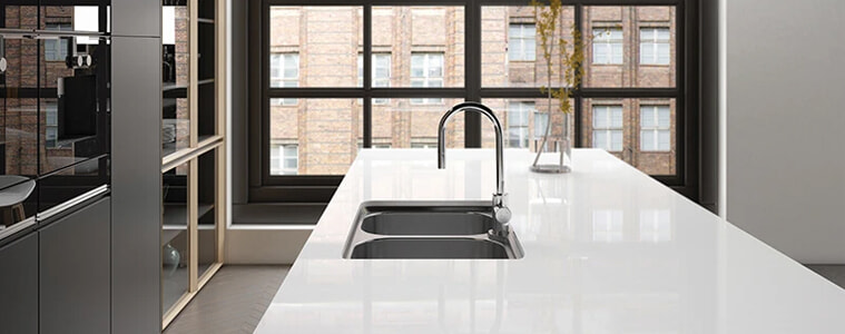 A chrome sink in the kitchen of a sleek modern apartment.