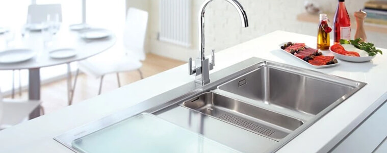 A silver stainless steel sink in a white kitchen.