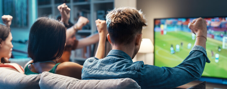 A group of friends watch soccer on their television.