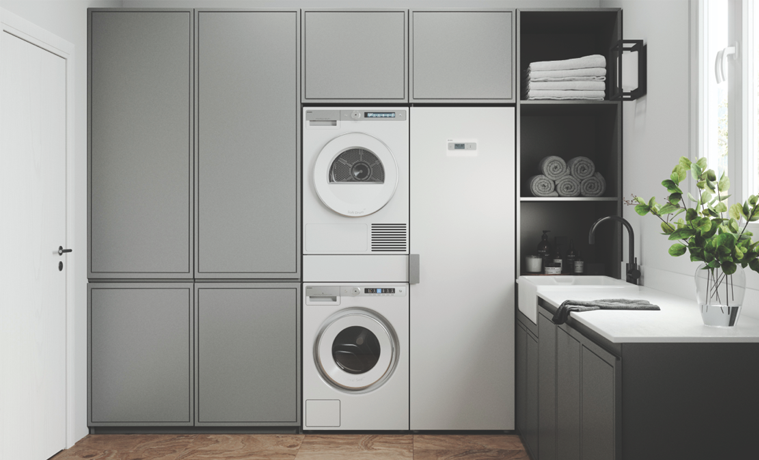 A white drying cabinet next to a matching washer and dryer in a neutral laundry.