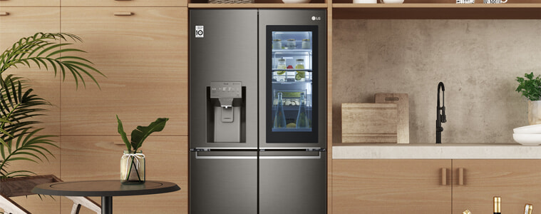 A smart fridge in a warm-toned wooden kitchen.