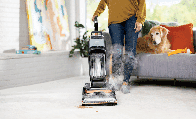 Woman steam cleans carpeted floor in living room
