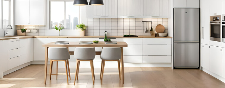 A minimal white Scandinavian kitchen with a silver bottom mount fridge.