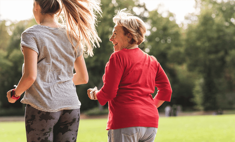 Mother and daughter jogging outside in a park