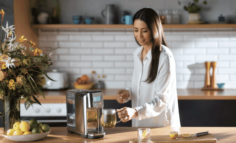 Woman getting hot tea from her water purifier. 