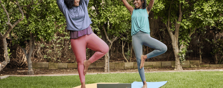 Women do yoga outside with their chromebook. 