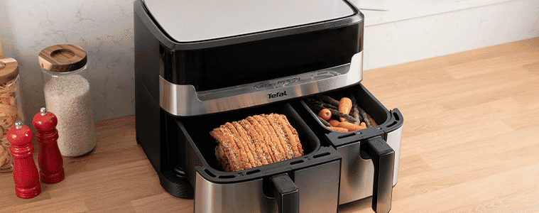 The Tefal Dual Easy Fry Airfryer with draws open displaying a cooked pork roast and vegetables on a modern kitchen bench