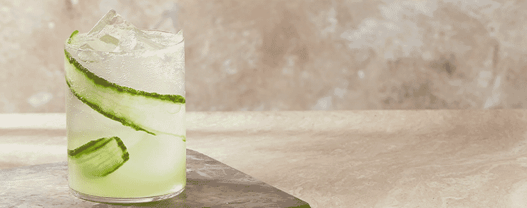 A glass filled with aarkes sparkling cucumber mint mocktail