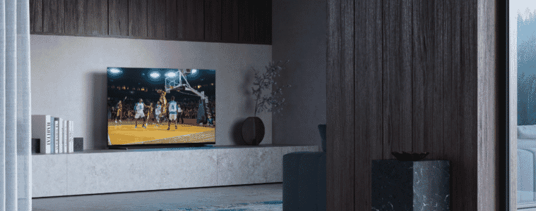 Image of the Sony 65" A80L 4K BRAVIA XR OLED Google TV 23 in a living room, with a basketball game playing on the TV.