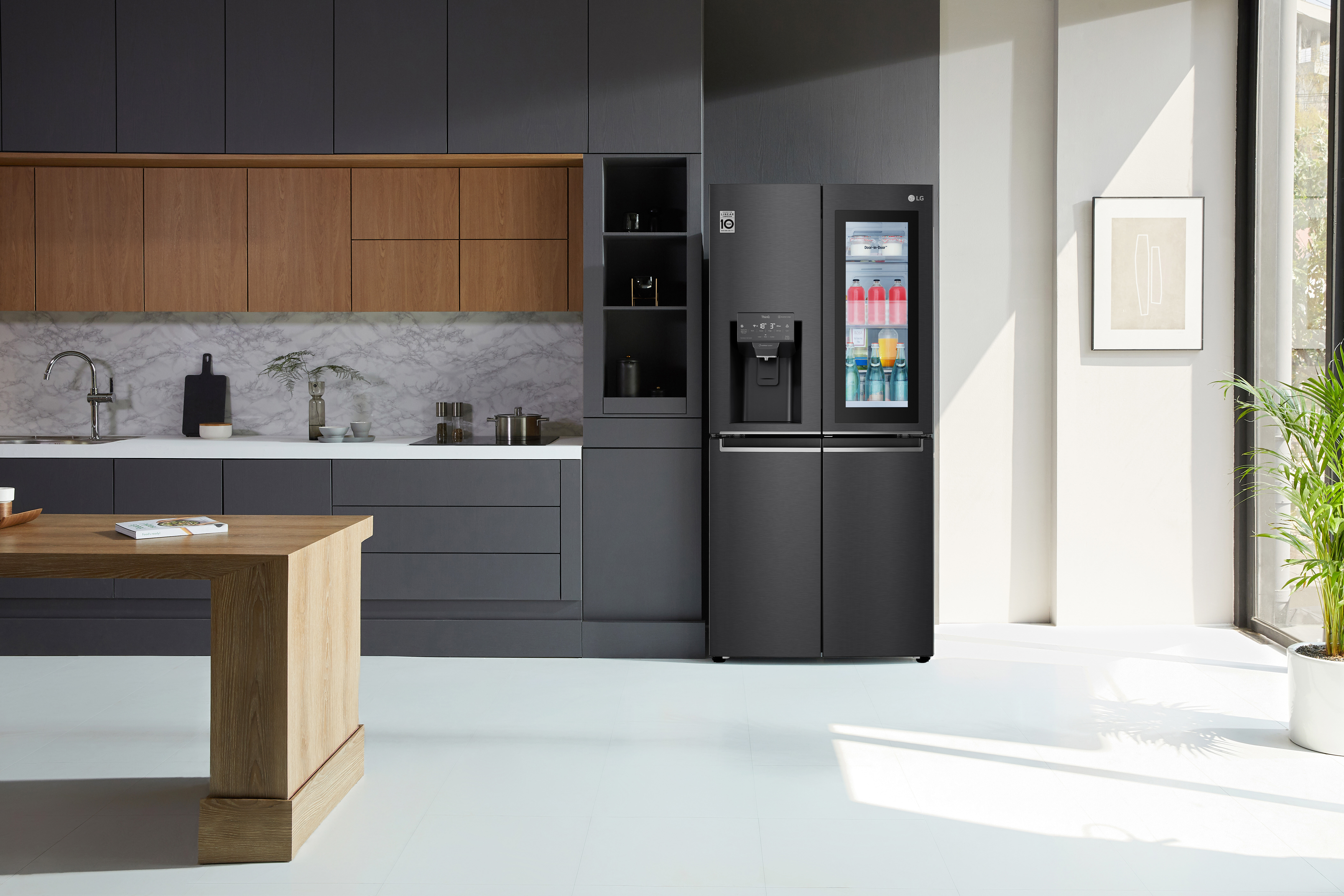 A black LG InstaView Fridge in a matching black kitchen with warm timber accents.