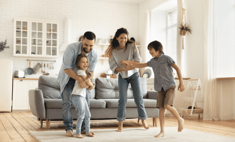 Happy family playing funny game having fun together with little son and daughter in modern living room.