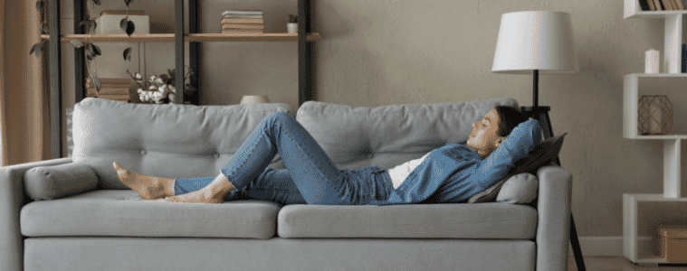 Side view woman enjoy day nap on comfy sofa.